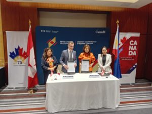 Dignitaries from the Canadian and Filipino Governments stand with FreeBalance's President and CEO. They are standing behind a desk with the Canadian and Filipino flags next to them. 